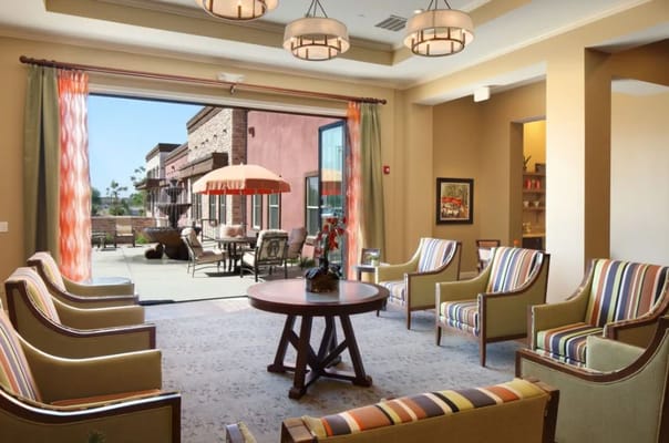 Lounge area with seating and outdoor view at Sky Vista senior living facility.