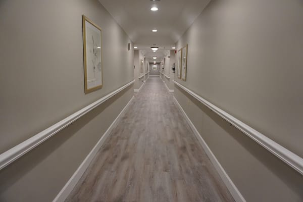 Long hallway with light-colored walls and wooden flooring