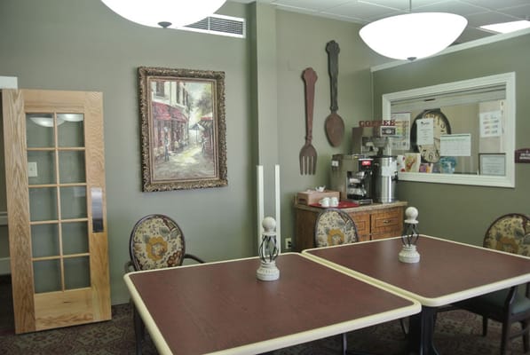 Cozy dining area with a decorative painting and coffee station.