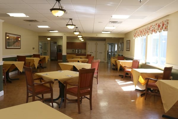 Empty dining area with yellow table covers and wooden chairs