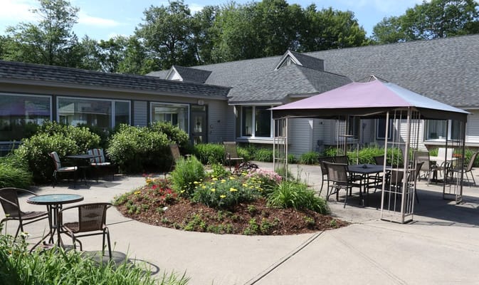 Patio with seating and flower garden at Starr Farm Nursing Center