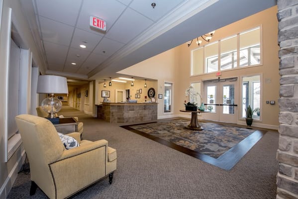 Lobby area with seating and reception desk at StoneCreek Assisted Living.