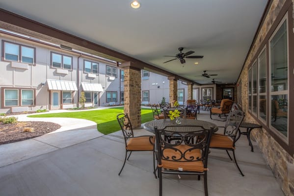 Outdoor patio with tables and chairs at StoneCreek Assisted Living