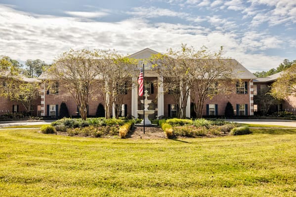 Front view of SummerHouse Park Provence building with landscaping and flag