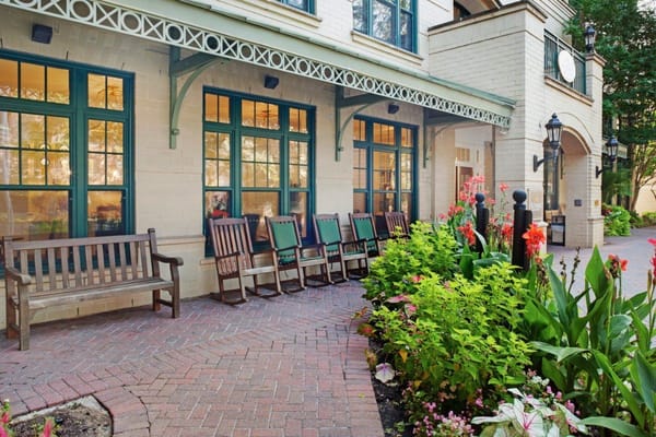 Entrance with seating and vibrant flower beds at Sunrise of Connecticut Ave