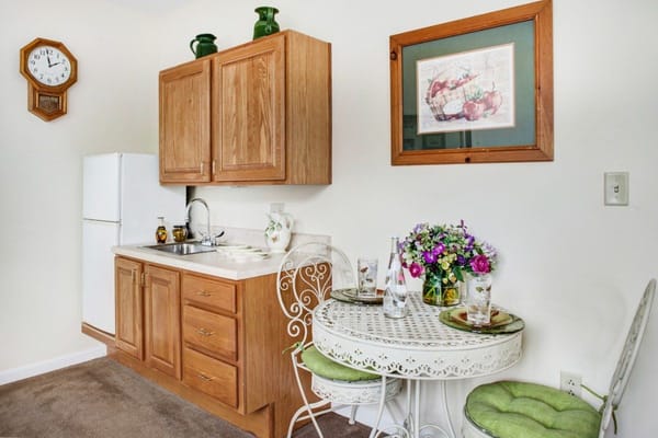 Small kitchenette with wooden cabinets and dining table