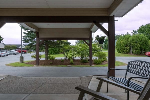 View from the entrance showing parked cars and greenery