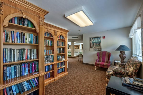 A library corner with wooden bookshelves and comfortable seating