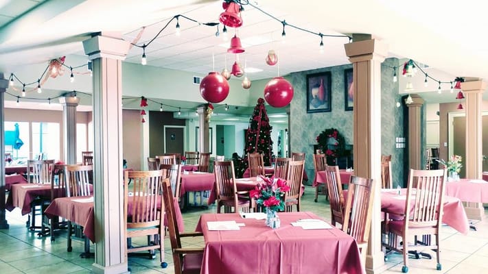 Decorated dining room with tables and a Christmas tree