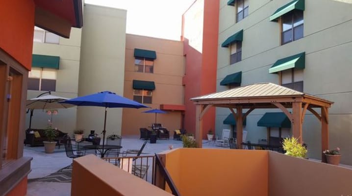 Outdoor courtyard with seating areas and umbrellas.