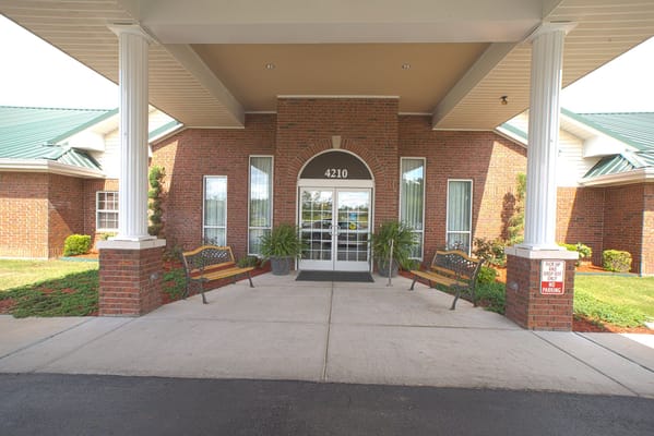 Main entrance of The Bungalows at Jonesboro with benches and greenery