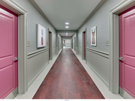 Brightly colored hallway with pink doors and framed artwork