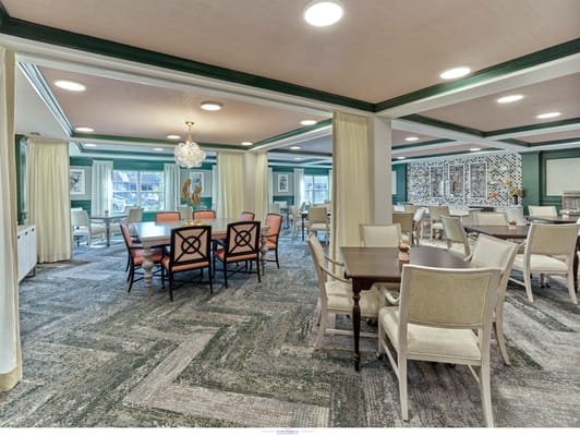 Spacious dining area with tables and chairs in a senior living facility