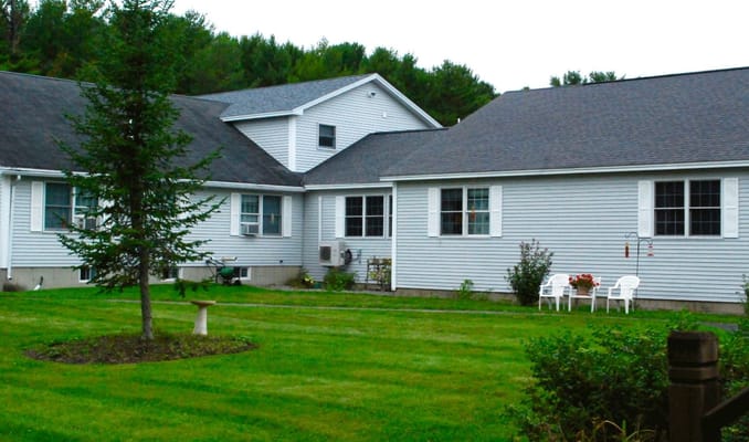 Exterior of The Country Villa senior living facility with grass and trees