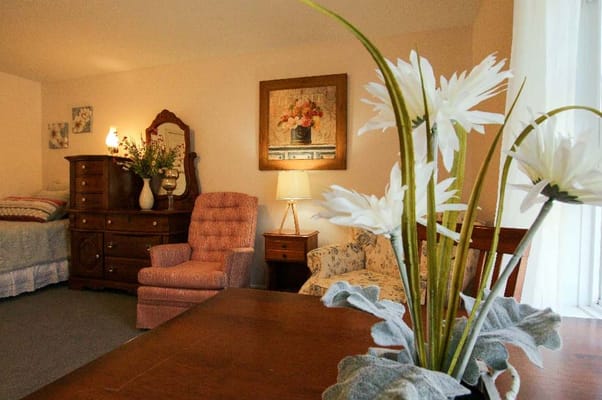 A comfortable living area with a floral arrangement in focus and soft seating.