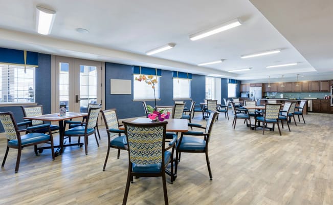 Bright and spacious dining room with wooden tables and patterned chairs