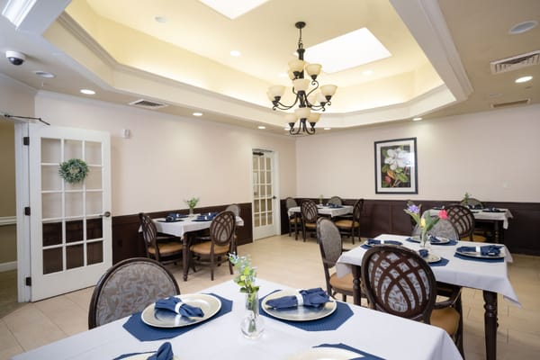 Elegant dining setup with tables and decorations in a facility dining room.