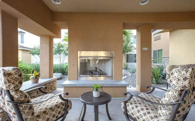 Seating area with patterned chairs and a decorative fireplace