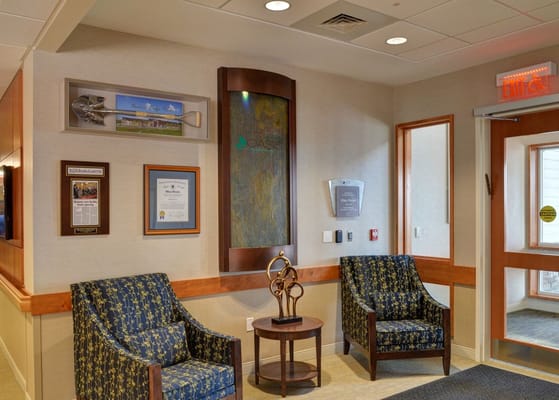 Lobby seating area with two chairs and decorative wall displays.