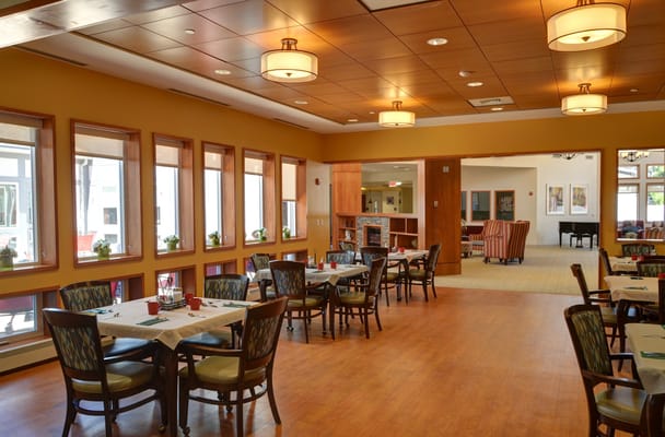 Bright dining room with tables and chairs at The Oasis at Dodge Park.