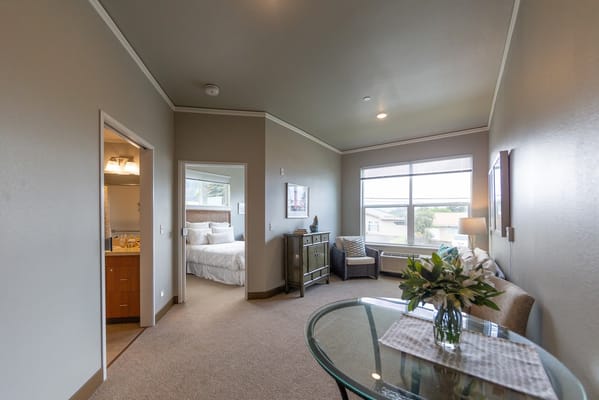 A cozy living room area with a view, featuring a table and a comfortable seating arrangement.