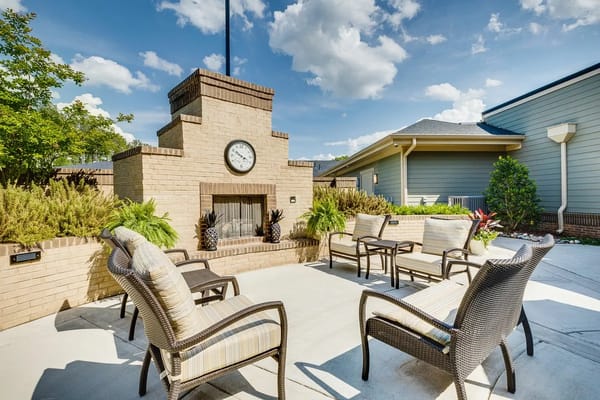 Cozy outdoor lounge area with comfortable seating and a clock.