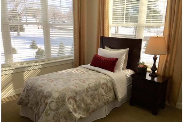 Cozy bedroom with twin bed and lamp near a window