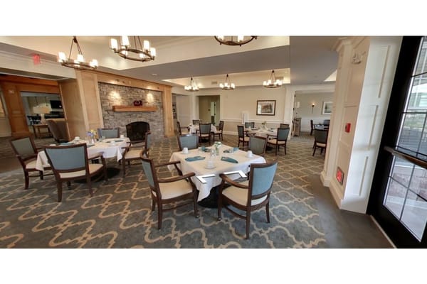 Bright dining room with tables set for meals at The Residence at Brookside
