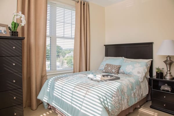 Bright and inviting bedroom with a bed, dresser, and a window.