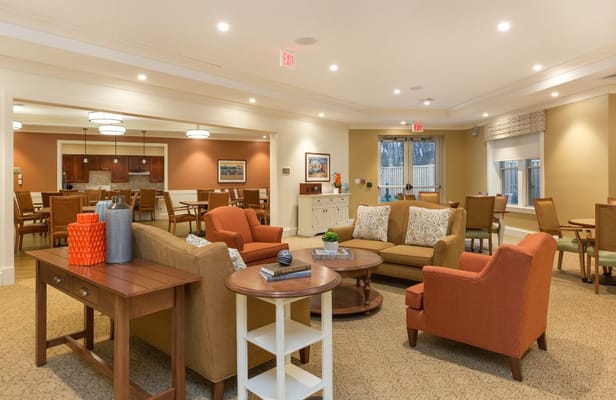 Spacious common area with seating and dining space in The Residence at Orchard Grove.