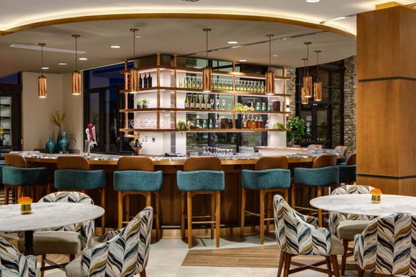 Interior view of the bar area with seating and shelves showcasing beverages.