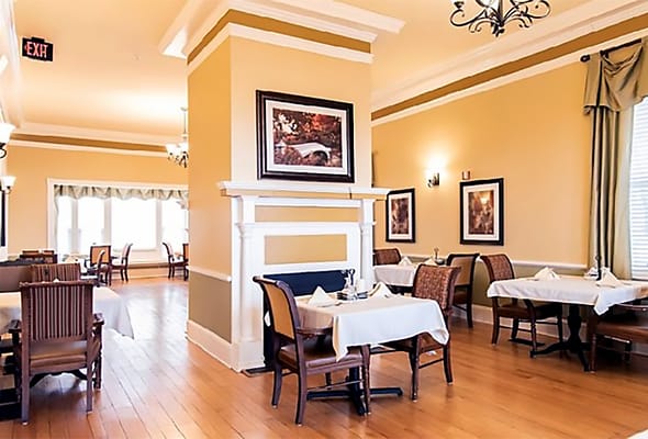 Cozy dining room featuring tables set for meals.