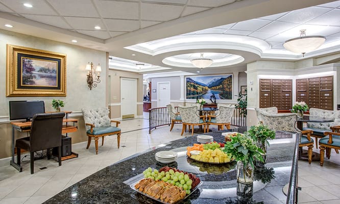 Spacious lobby with seating, fruit display, and computer station.