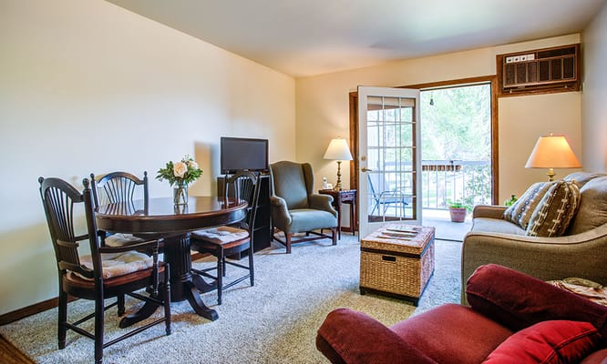 Comfortable living room with a table, chairs, and balcony access.