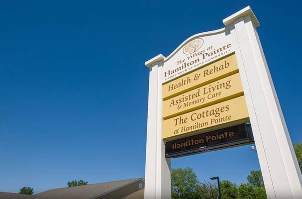 Sign for The Village at Hamilton Pointe showing services offered
