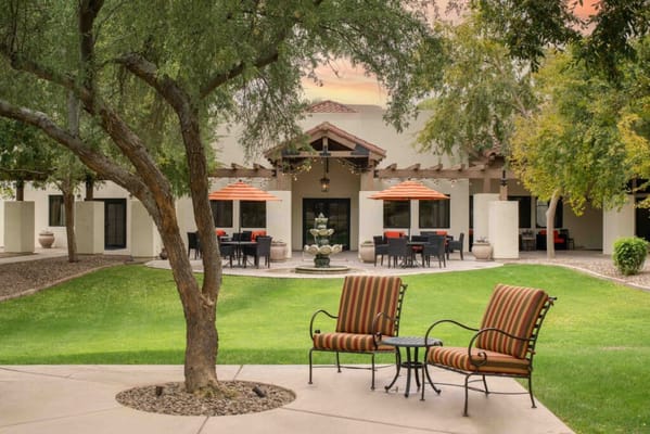 Outdoor seating area in the garden with a fountain and dining tables.