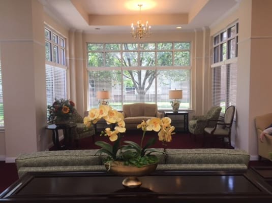 Living room with seating, lamps, and large windows
