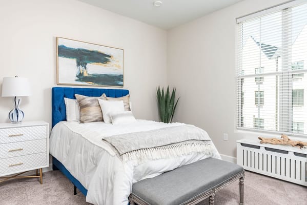 Bright bedroom with blue upholstered bed and modern decor