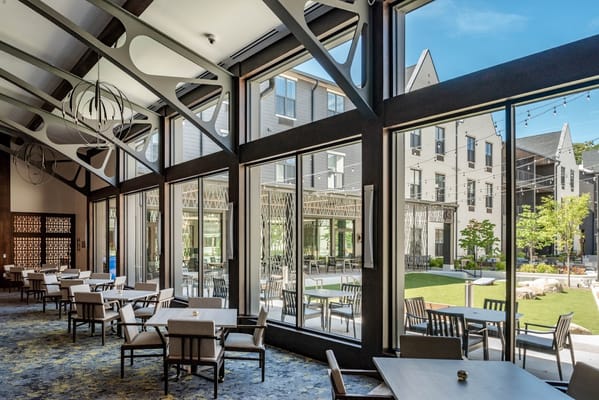 Interior dining area with large windows overlooking outdoor space