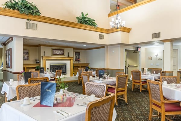 Dining area with tables set for meals at Truewood by Merrill.