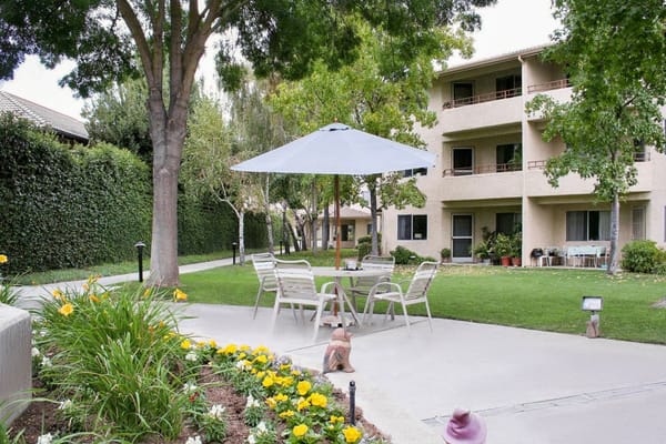Outdoor patio area with seating and greenery at Truewood by Merrill, Fig Garden.
