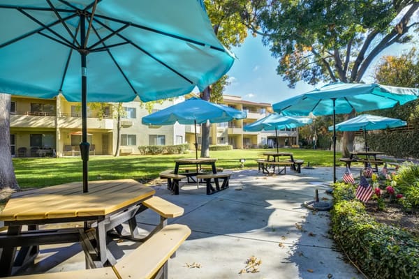 Patio area with picnic tables and blue umbrellas