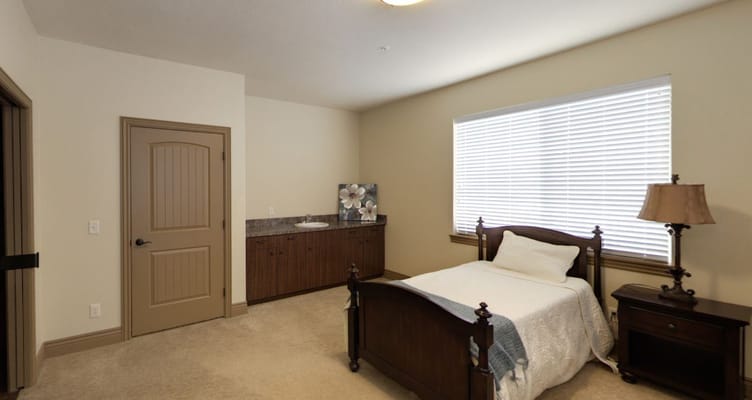 A well-furnished private resident room with a bed and a window