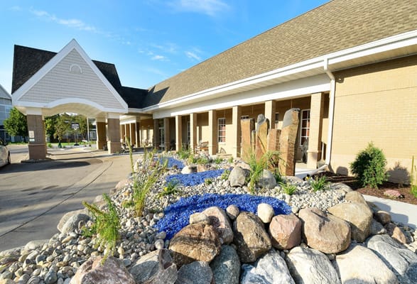 Beautifully landscaped entrance with rocks and blue glass pebbles.