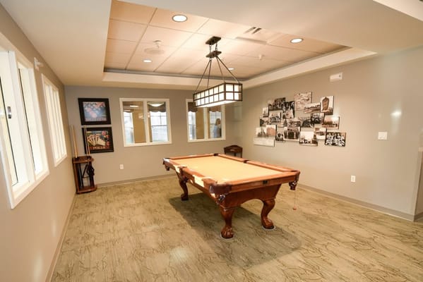 Common area with a pool table and framed photos