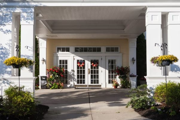 Entrance of a senior living facility adorned with flowers