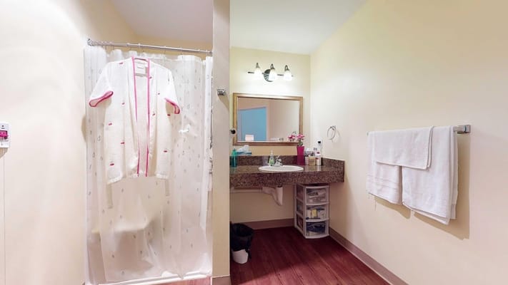 A cozy bathroom featuring a shower curtain, sink, and towels.