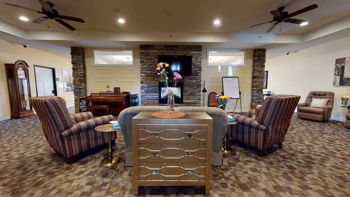 Living room area with armchairs, floral decor, and a stone fireplace