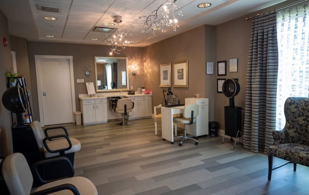 Bright and welcoming hair salon area with chairs and mirrors