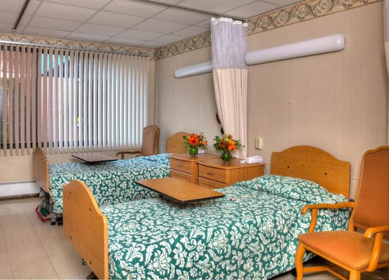 A well-furnished resident room with two beds and flowers